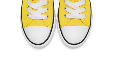 Photo of Pair of yellow classic old school sneakers isolated on white, top view