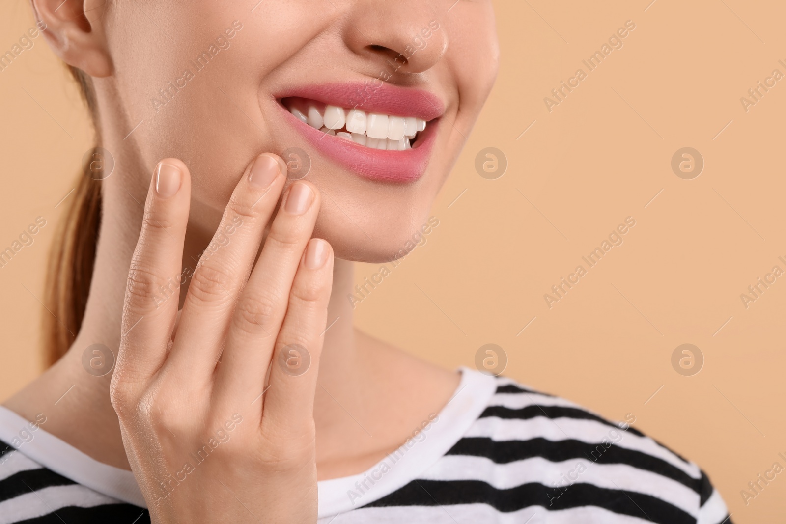 Photo of Woman with clean teeth smiling on beige background, closeup. Space for text