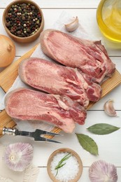 Photo of Raw beef tongue pieces and spices on white wooden table, flat lay