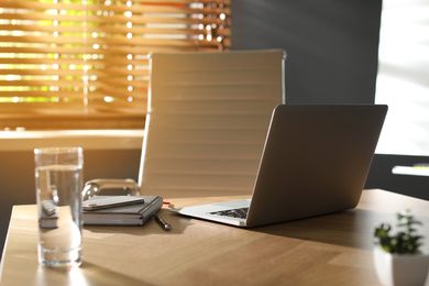 Laptop on wooden table in modern office