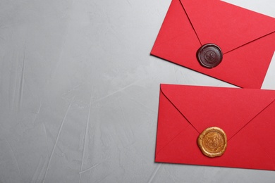 Photo of Red envelopes with wax seals on grey background, flat lay. Space for text
