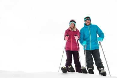 Photo of Couple of skiers on slope at resort, space for text. Winter vacation