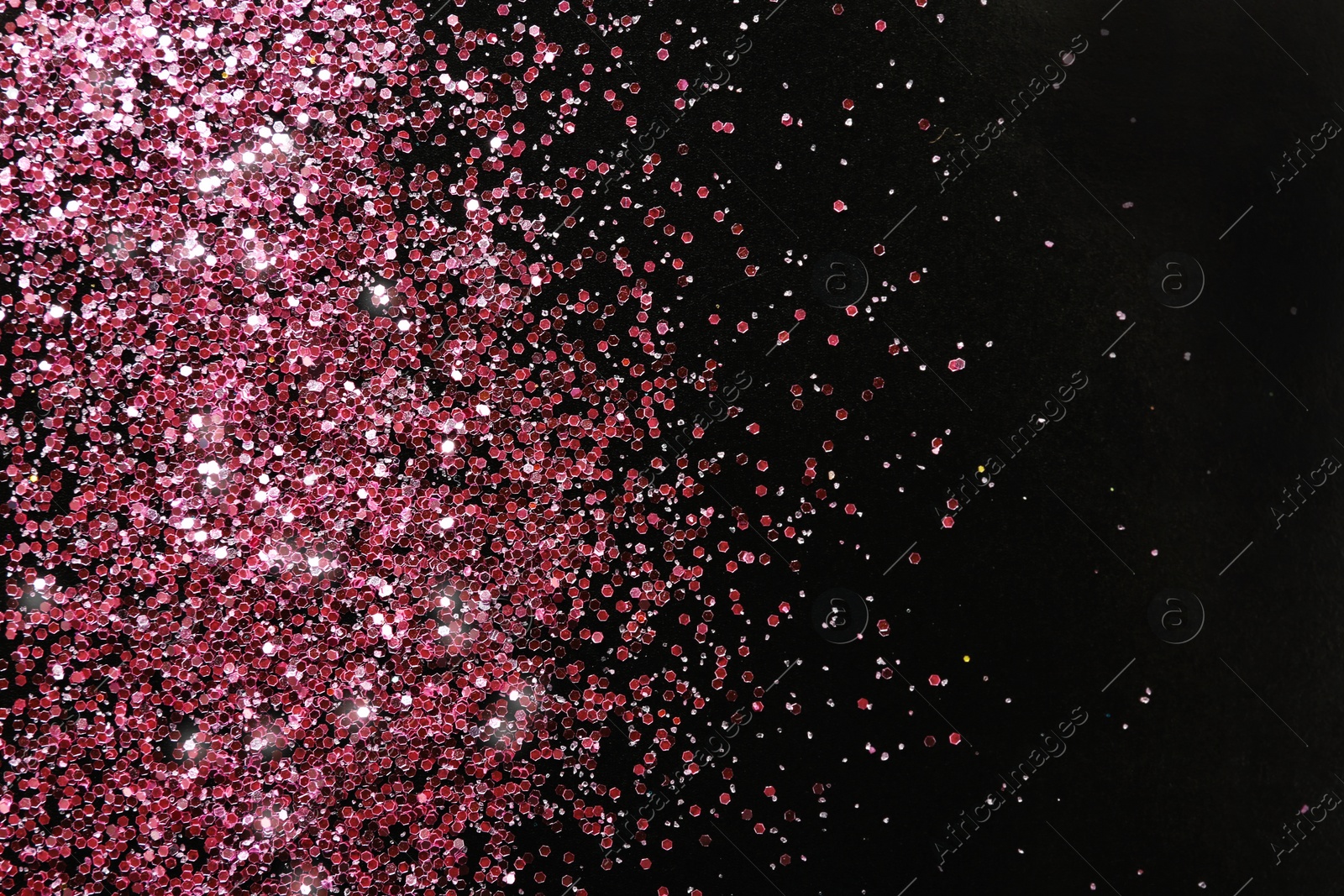 Photo of Rose gold glitter on black background, top view with space for text