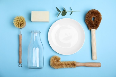 Flat lay composition with cleaning supplies for dish washing on light blue background, flat lay