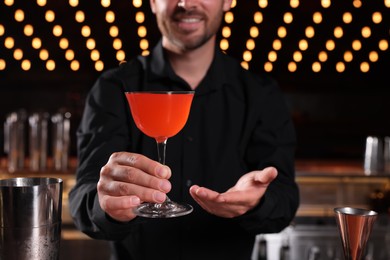 Photo of Bartender with fresh alcoholic cocktail in bar, closeup