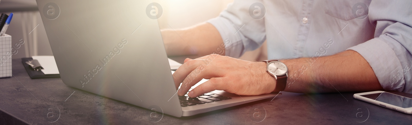 Image of Young man working on computer at table indoors, closeup. Banner design