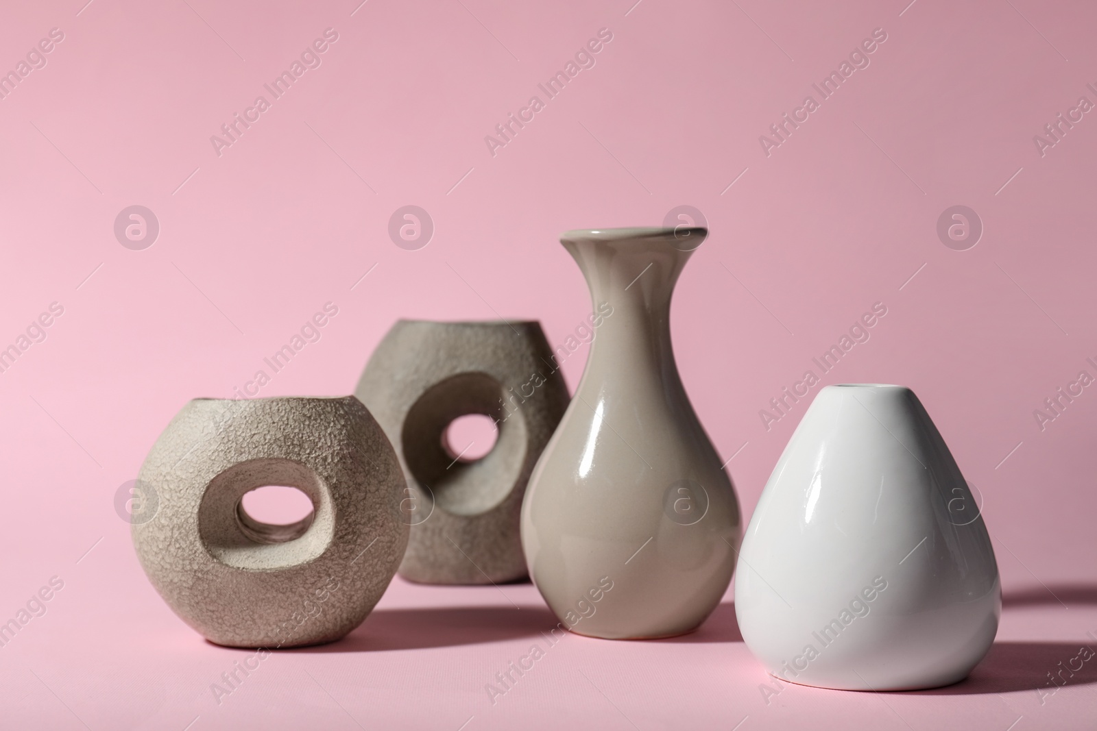 Photo of Different stylish vases and branch on pink background