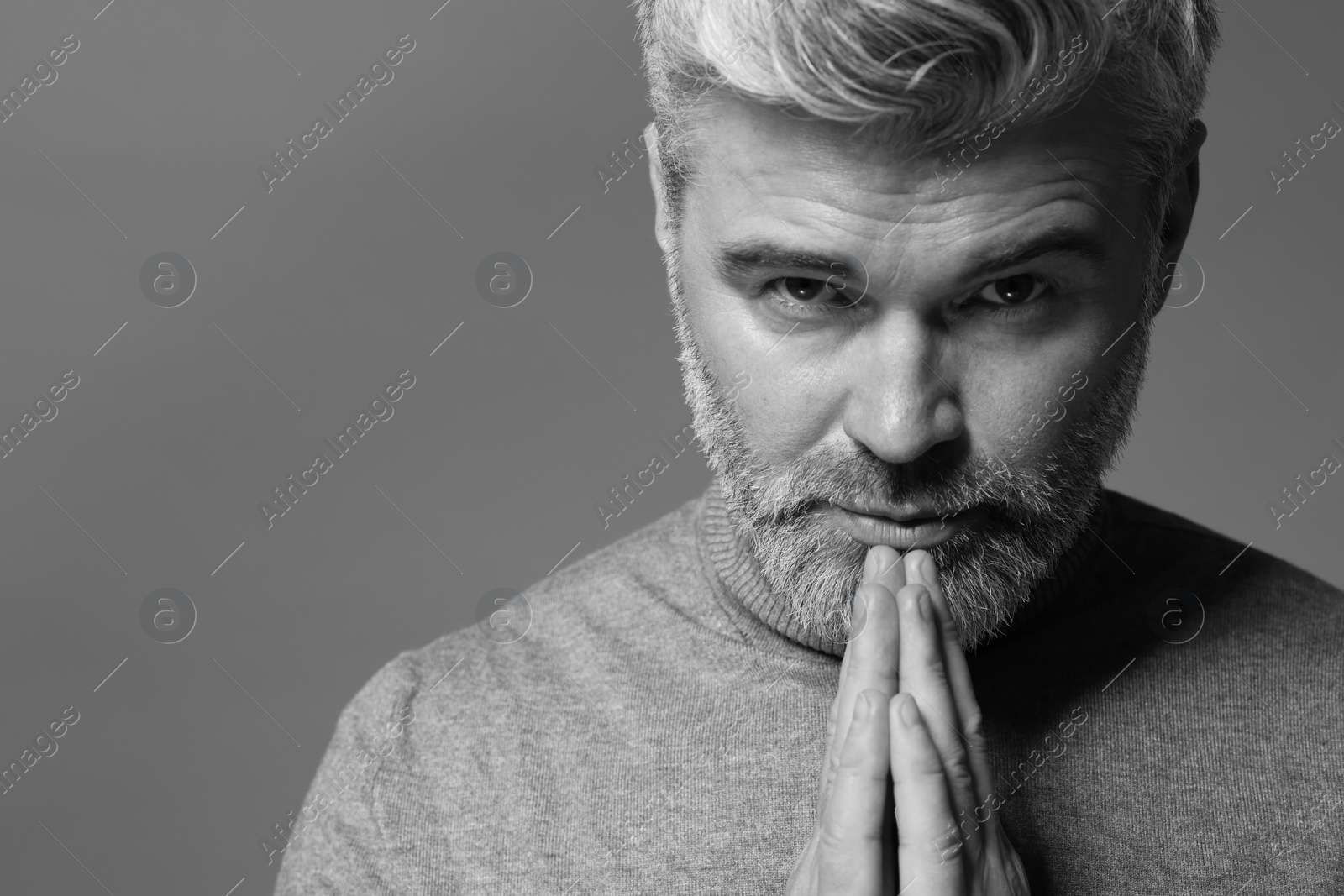 Photo of Portrait of handsome man on grey background. Black and white effect