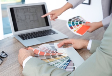 Team of designers working with color palettes at office table, closeup