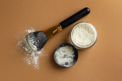 Photo of Rice loose face powder and makeup brush on brown background, flat lay