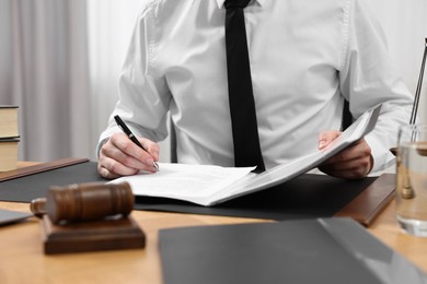 Photo of Lawyer working with documents at table indoors, closeup