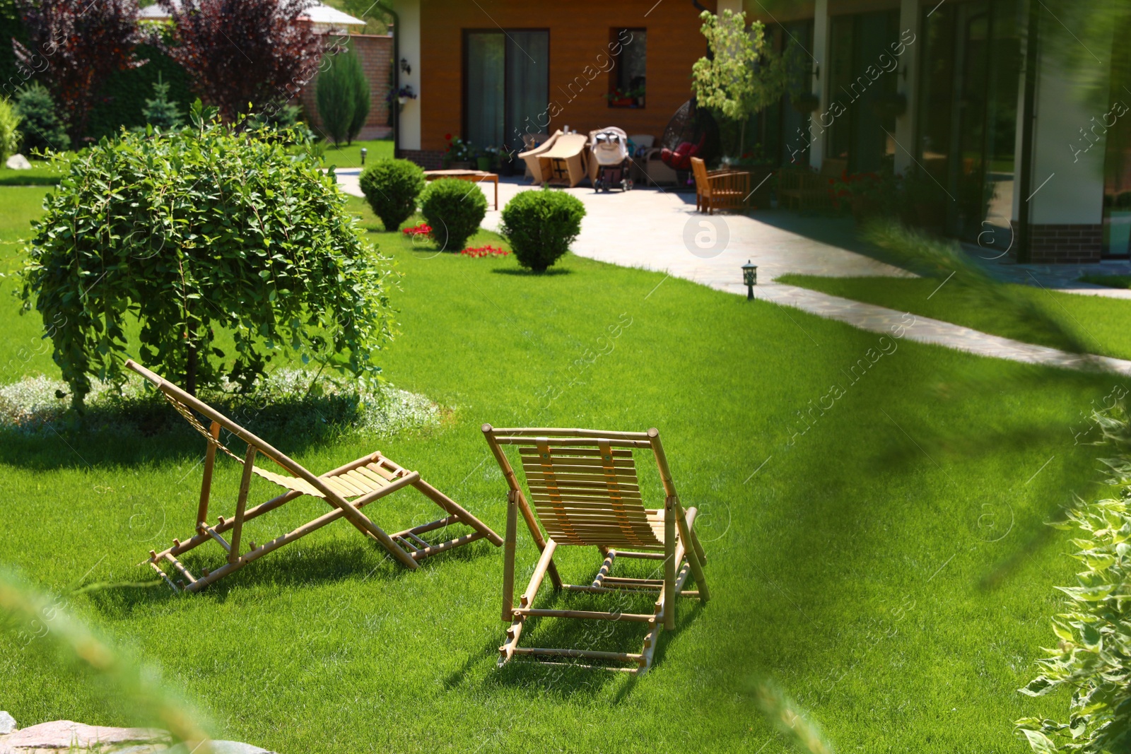 Photo of Wooden deck chairs in beautiful garden on sunny day