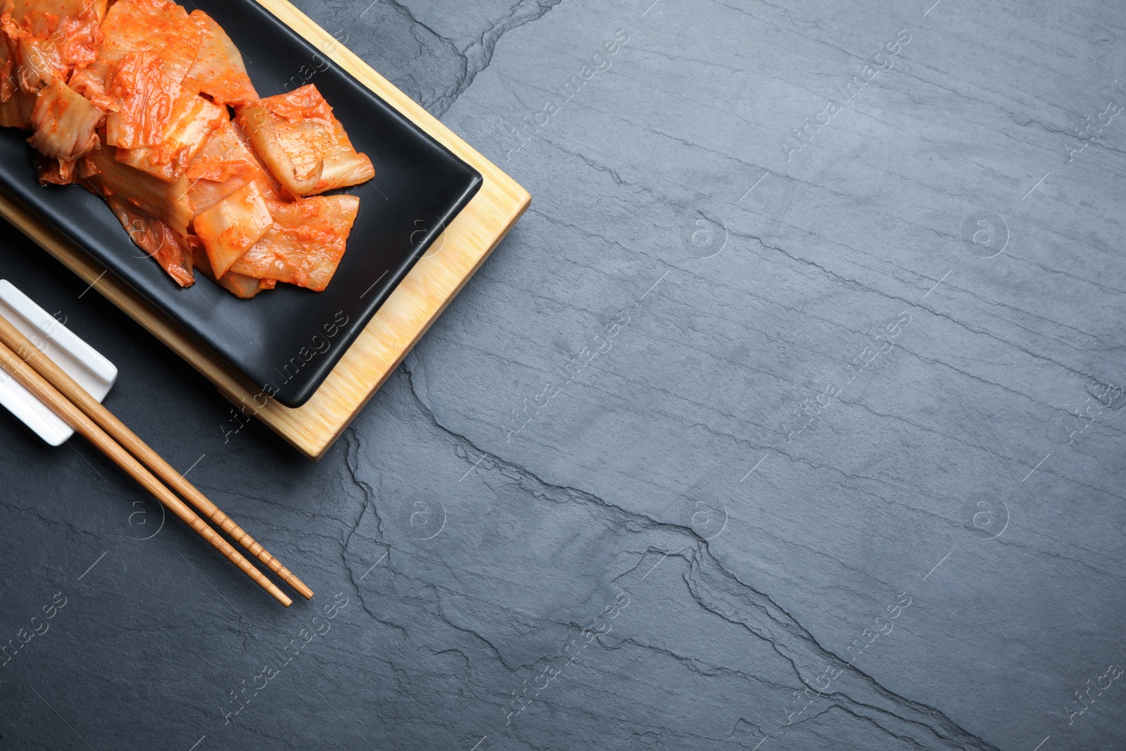 Photo of Delicious kimchi with Chinese cabbage served on grey table, flat lay. Space for text