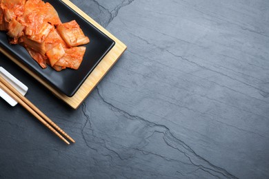 Delicious kimchi with Chinese cabbage served on grey table, flat lay. Space for text