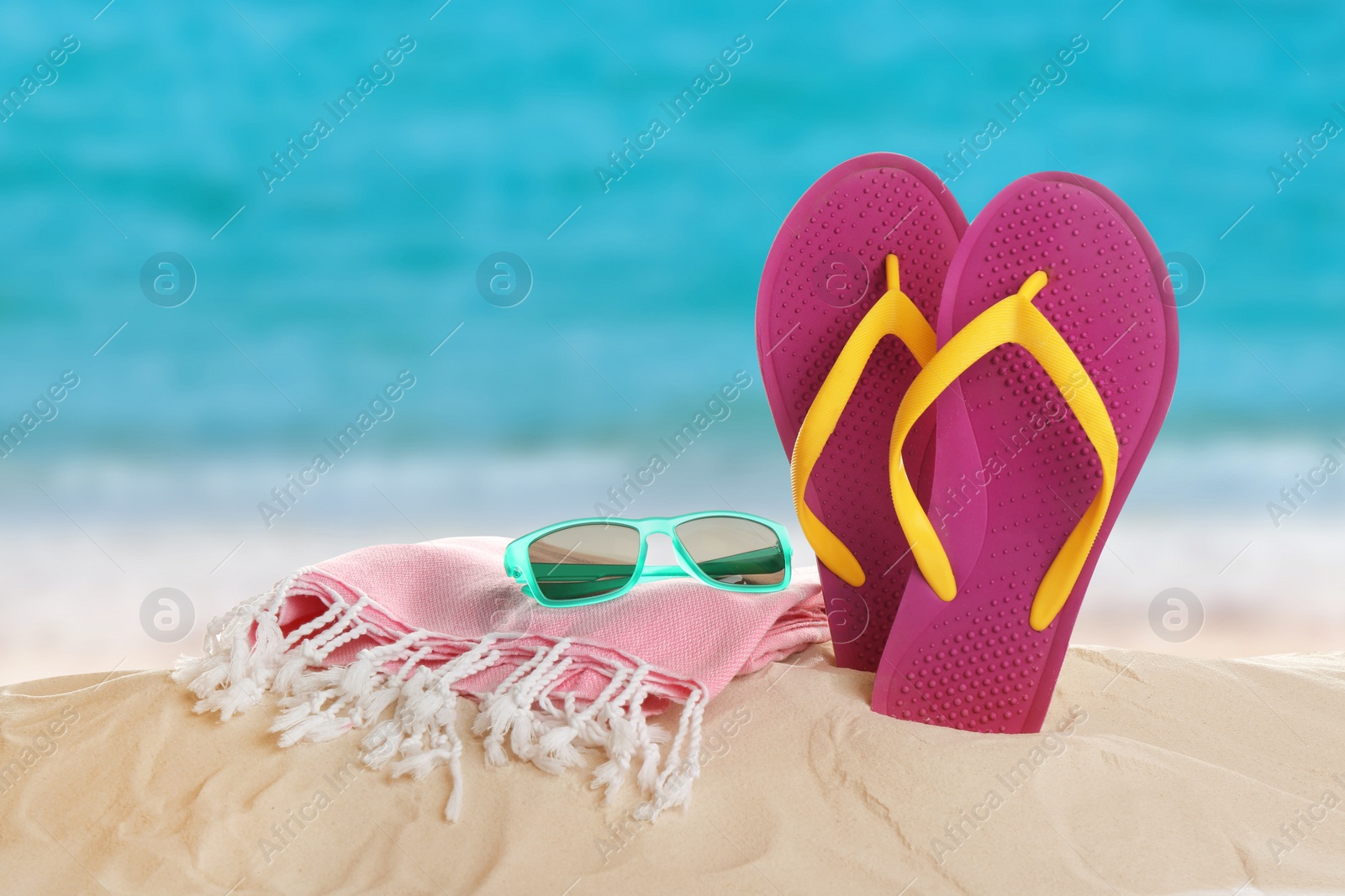 Image of Different beach accessories on sand near sea