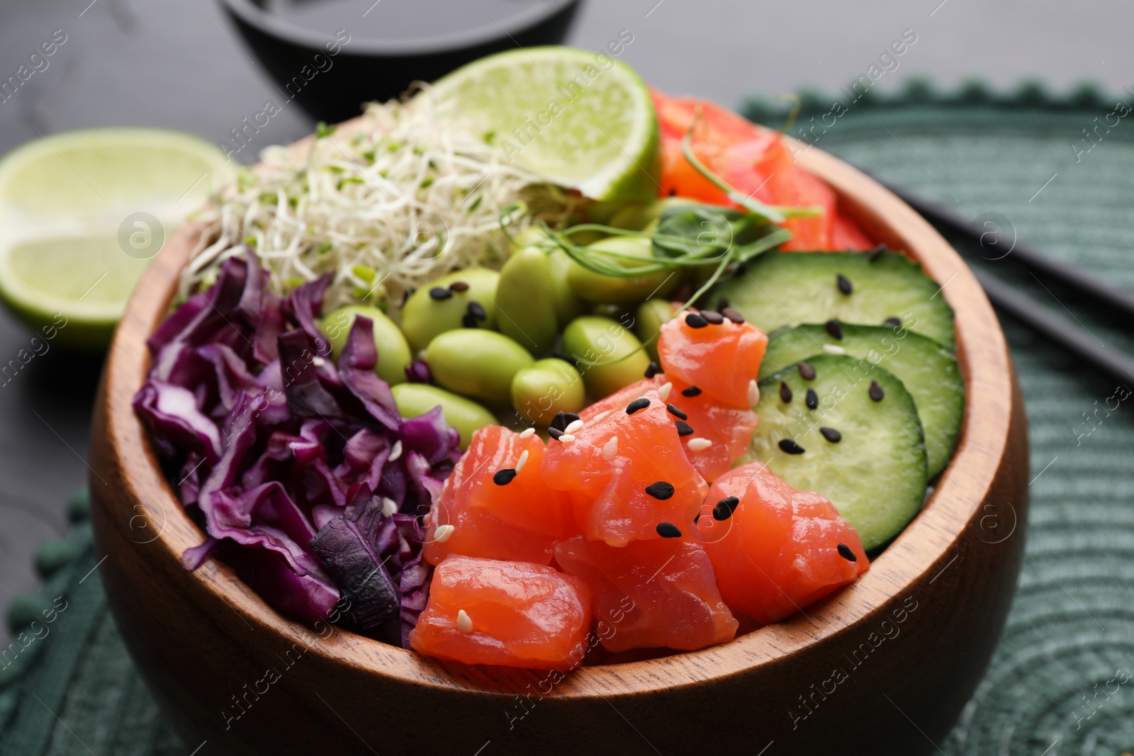 Photo of Delicious poke bowl with vegetables, fish and edamame beans on table, closeup