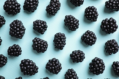 Photo of Tasty ripe blackberries on light blue background, flat lay