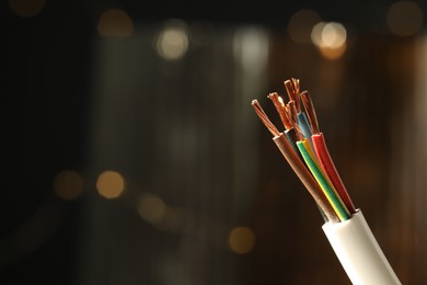 Photo of Cable with copper wires against blurred background, closeup. Space for text