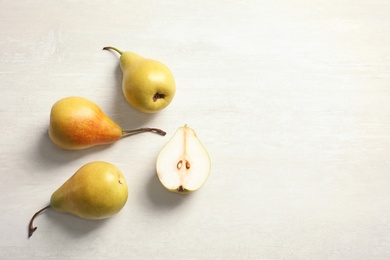 Photo of Flat lay composition with ripe pears on light background. Space for text