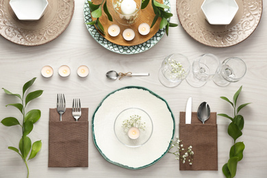 Photo of Elegant table setting with green plants on white wooden background, flat lay