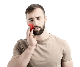 Young man suffering from toothache on white background