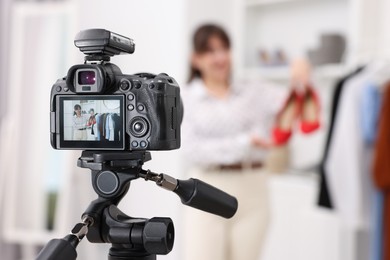 Fashion blogger showing her shoes while recording video at home, focus on camera