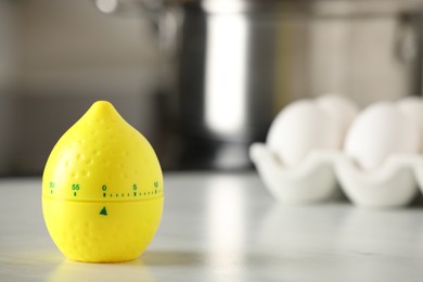 Photo of Kitchen timer in shape of lemon on white table indoors. Space for text