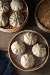 Delicious bao buns (baozi) on wooden table, flat lay