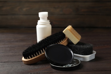 Photo of Composition with shoe care accessories on wooden table