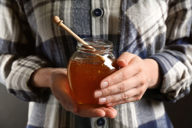 Photo of Woman with jar of fresh honey, closeup