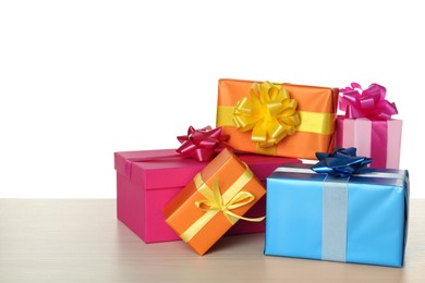 Photo of Colorful gift boxes on wooden table against white background, space for text