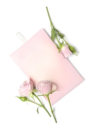 Photo of Scented sachet and pink roses on white background, top view