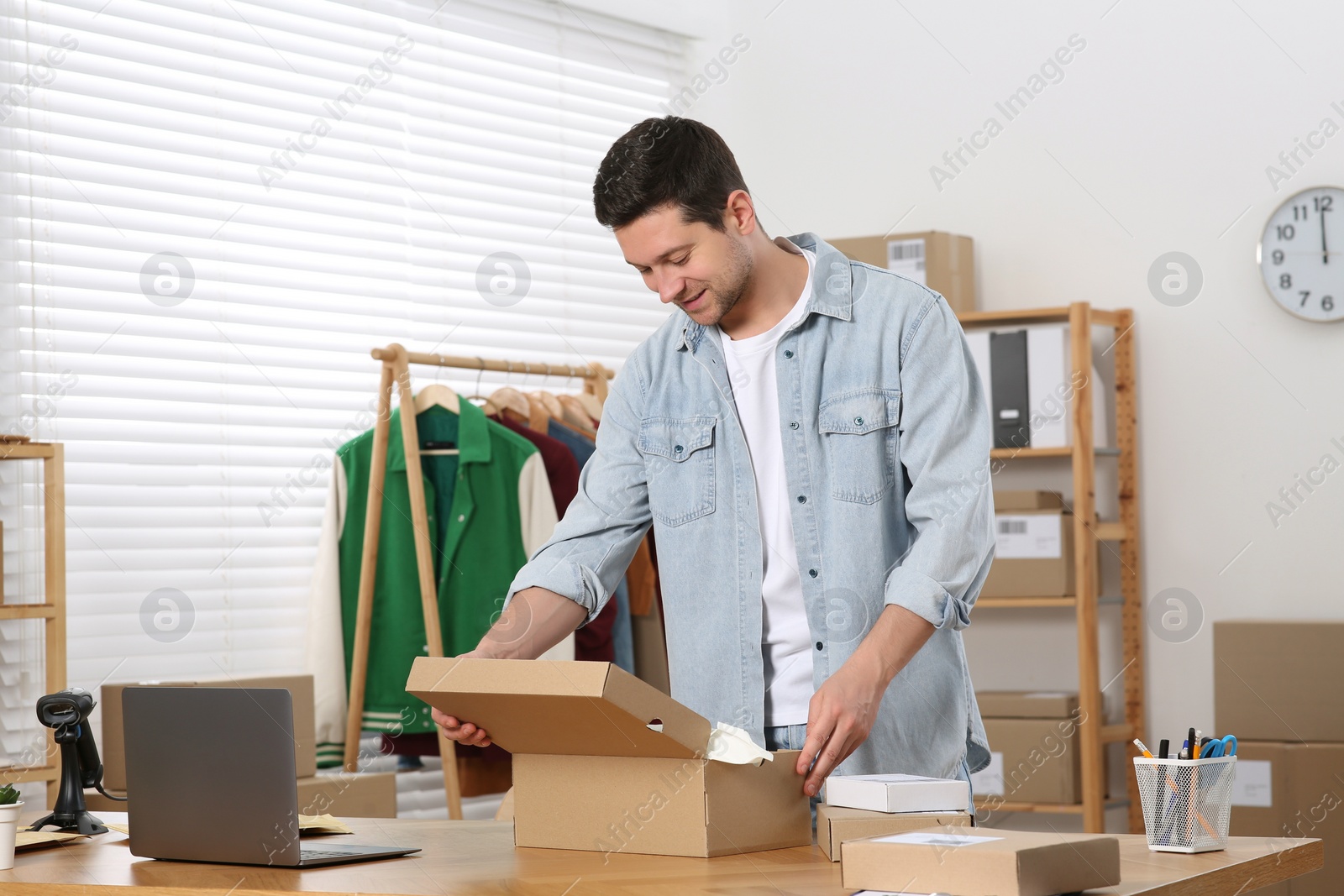 Photo of Seller packing parcel at workplace. Online store