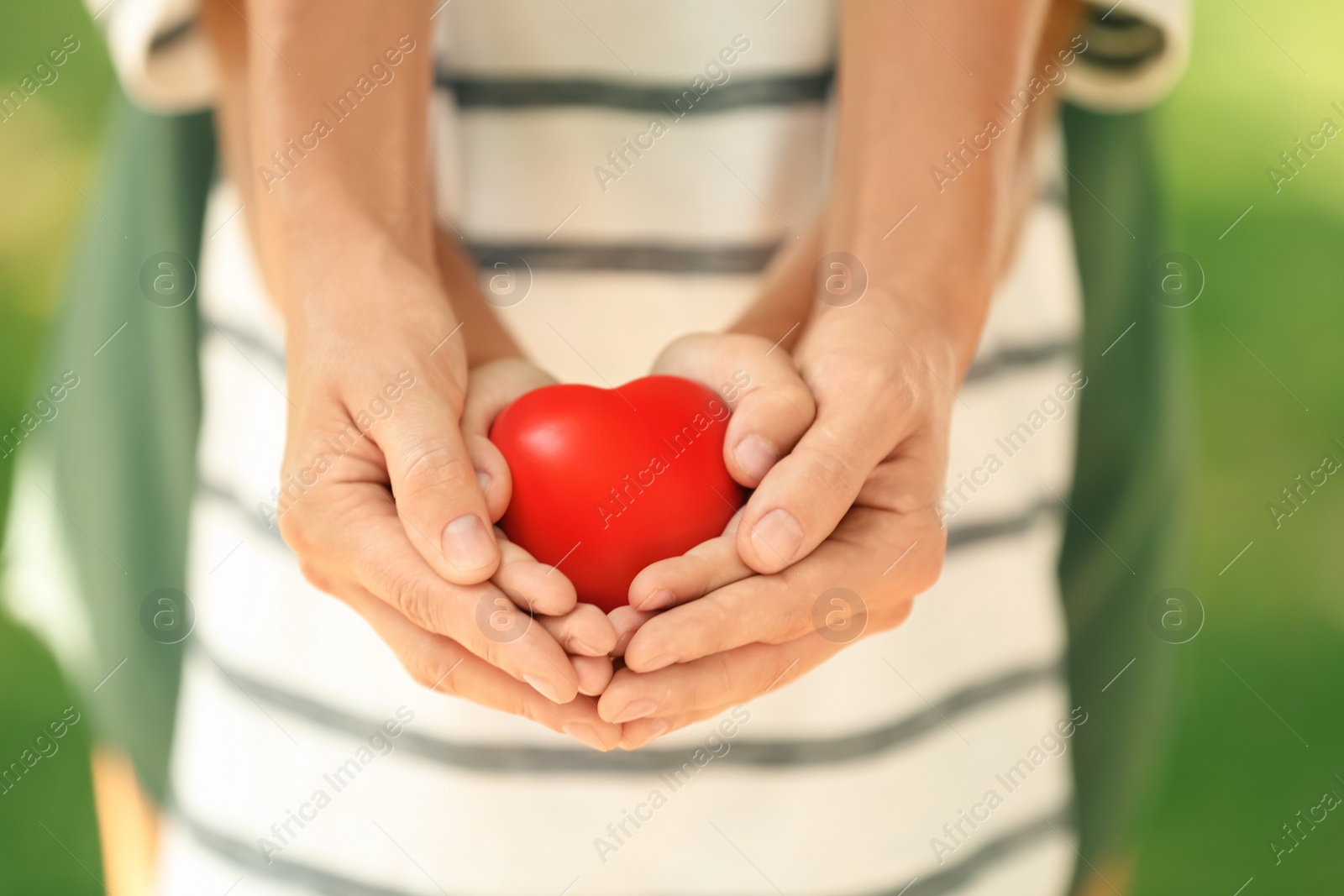 Photo of Adult and child hands holding heart on blurred background, closeup. Family concept