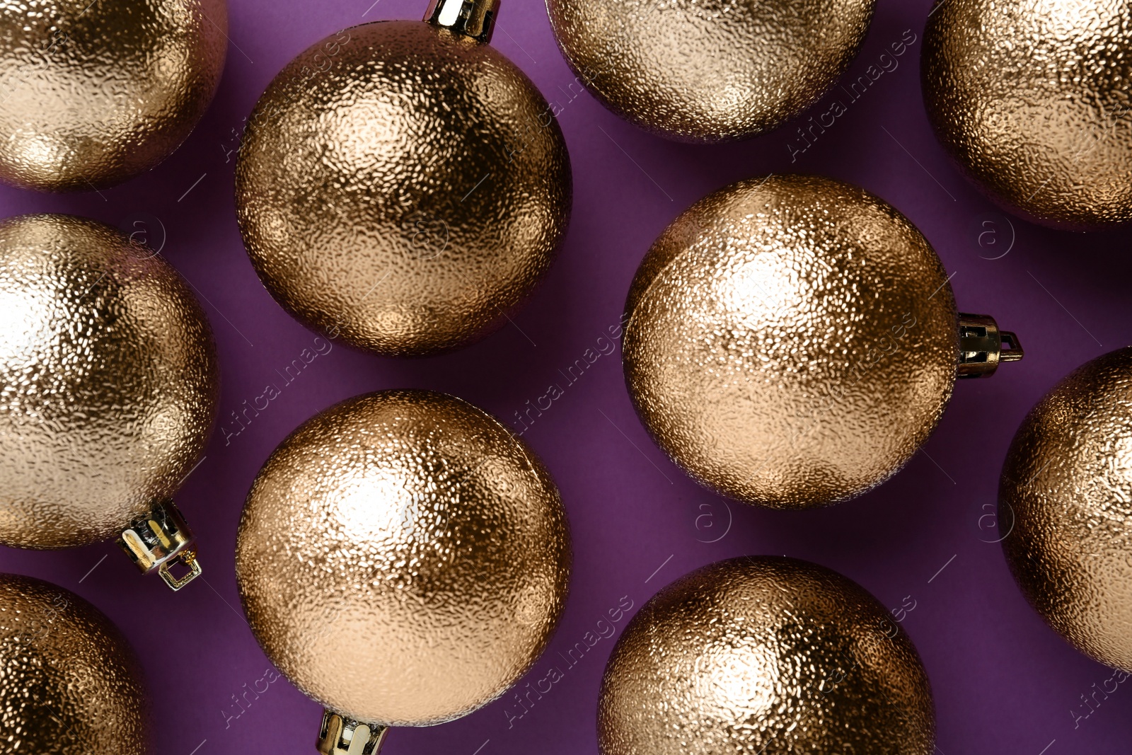 Photo of Many shiny Christmas balls on purple background, flat lay
