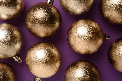 Photo of Many shiny Christmas balls on purple background, flat lay