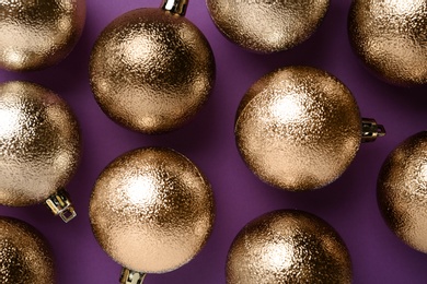 Many shiny Christmas balls on purple background, flat lay