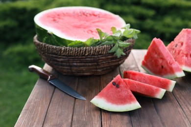 Tasty ripe watermelon on wooden table outdoors