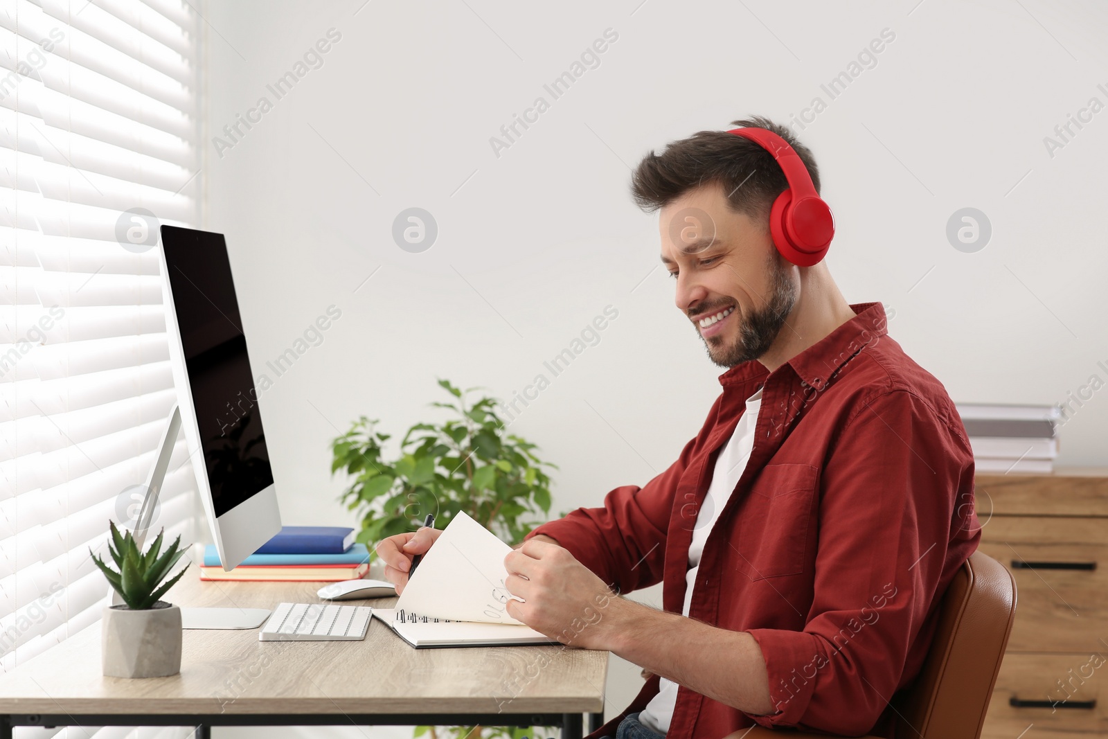 Photo of Man in headphones studying on computer at home. Online translation course