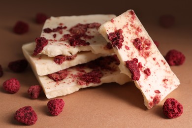 White chocolate with freeze dried raspberries on brown table, closeup