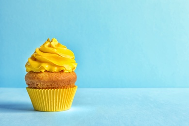 Photo of Delicious birthday cupcake with cream on color background