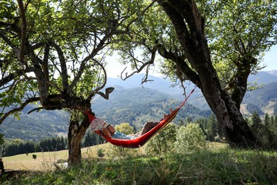 Man resting in hammock outdoors on sunny day