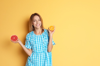 Photo of Happy slim woman with grapefruit and orange on color background. Weight loss diet