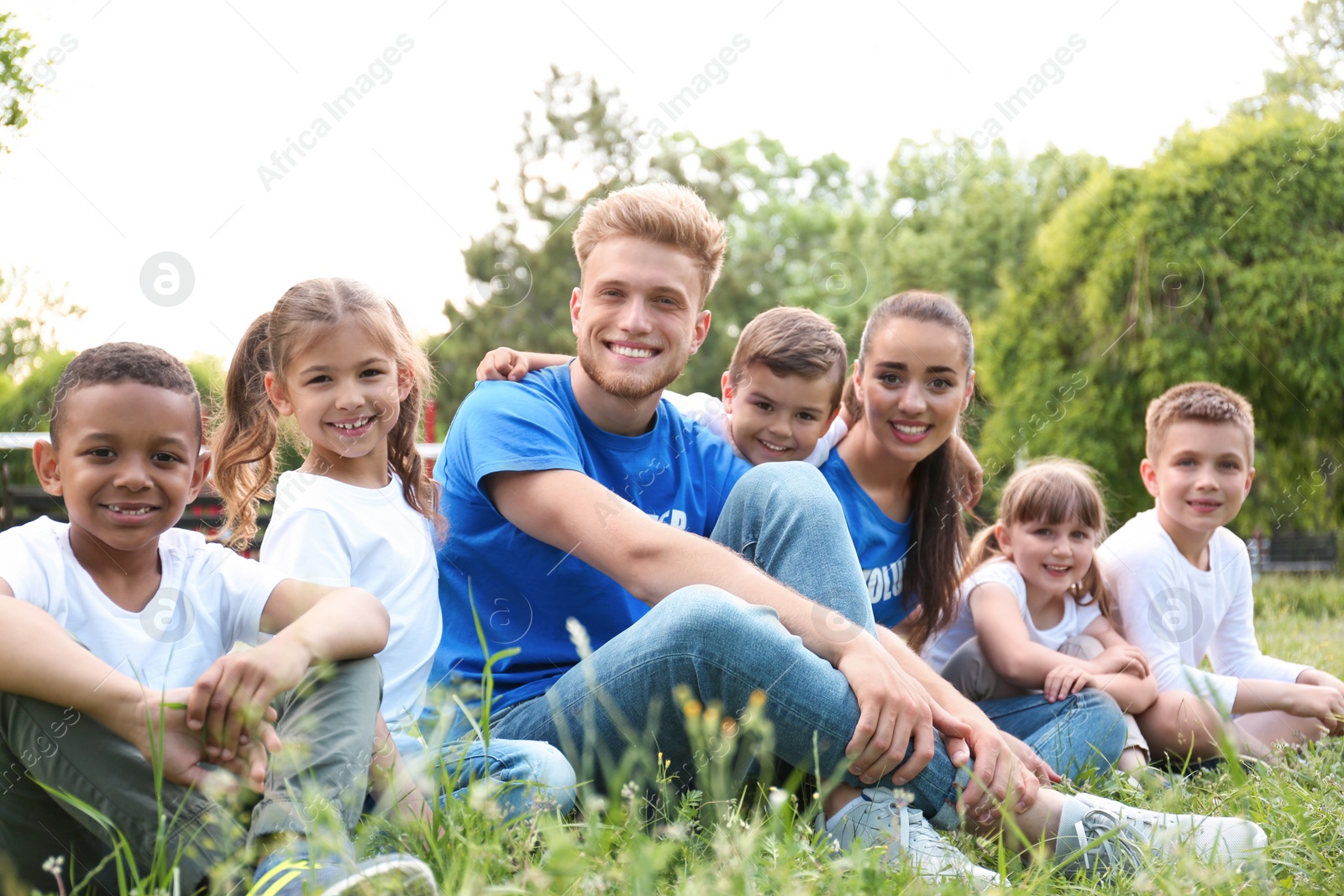 Photo of Volunteers and kids sitting on grass in park