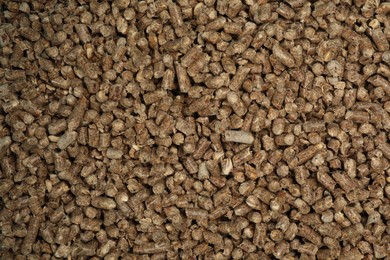 Photo of Wood pellet cat litter as background, closeup