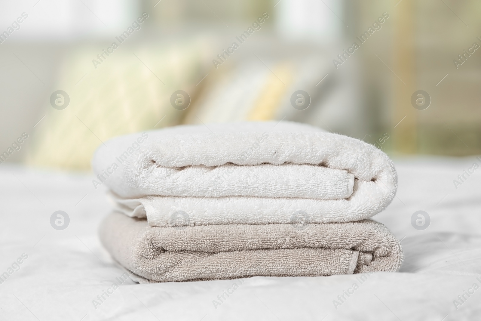 Photo of Stack of clean terry towels on bed, closeup