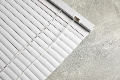 Photo of Stylish horizontal window blinds on grey table, top view