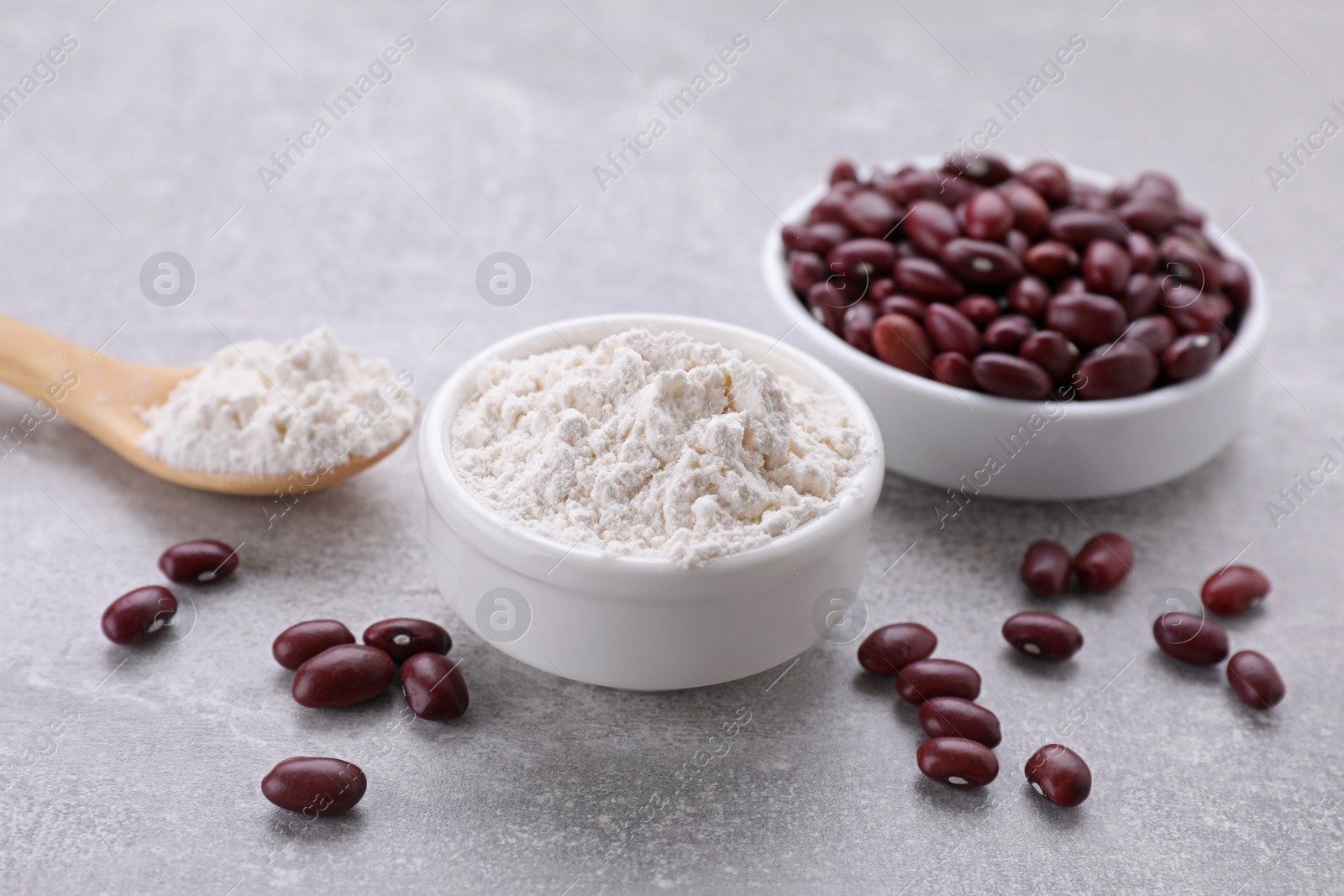 Photo of Kidney bean flour and seeds on light grey table