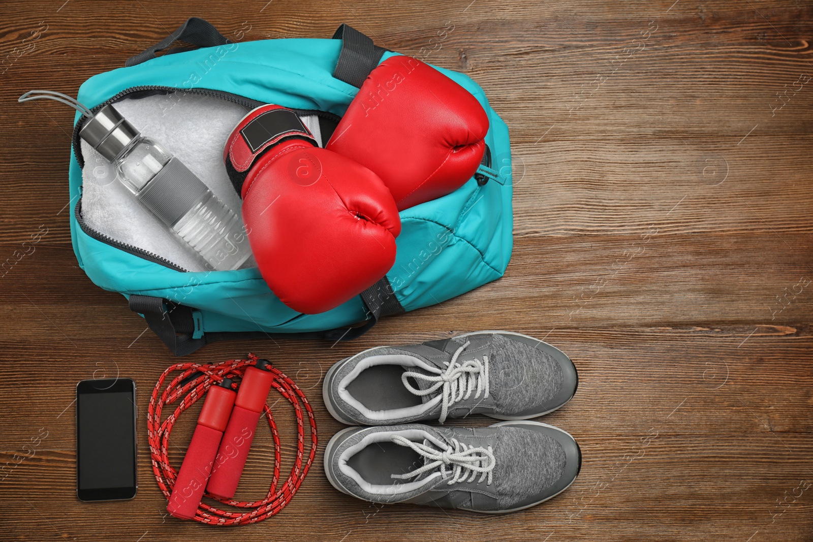 Photo of Sports bag and gym equipment on wooden background, top view