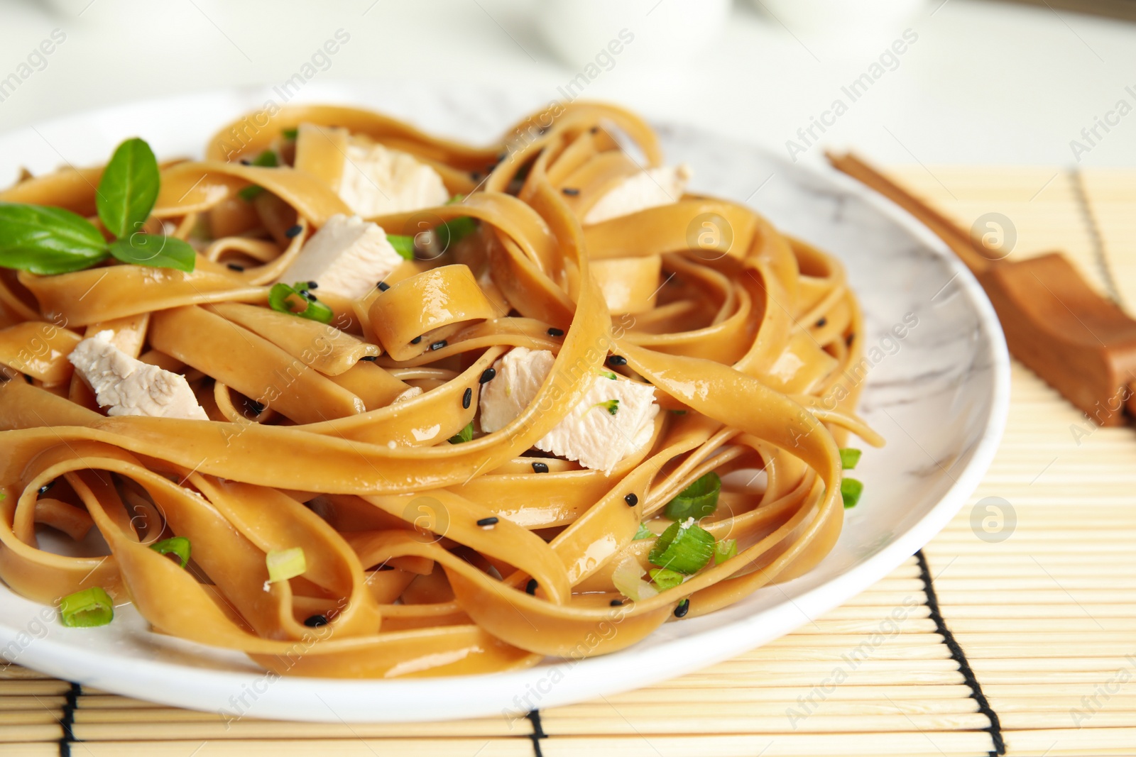 Photo of Tasty buckwheat noodles with meat served on table, closeup